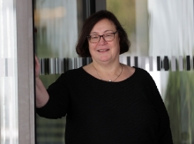 Frau mit kurzen braunen Haaren, Brille und schwarzem Oberteil