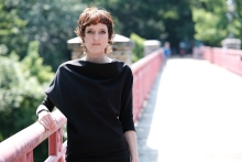 Frau auf Brücke mit kurzen Haaren und schwarzem Kleid