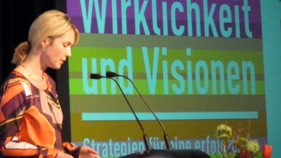 Manuela Schwesig vor Plakat Wirklichkeit und Visionen