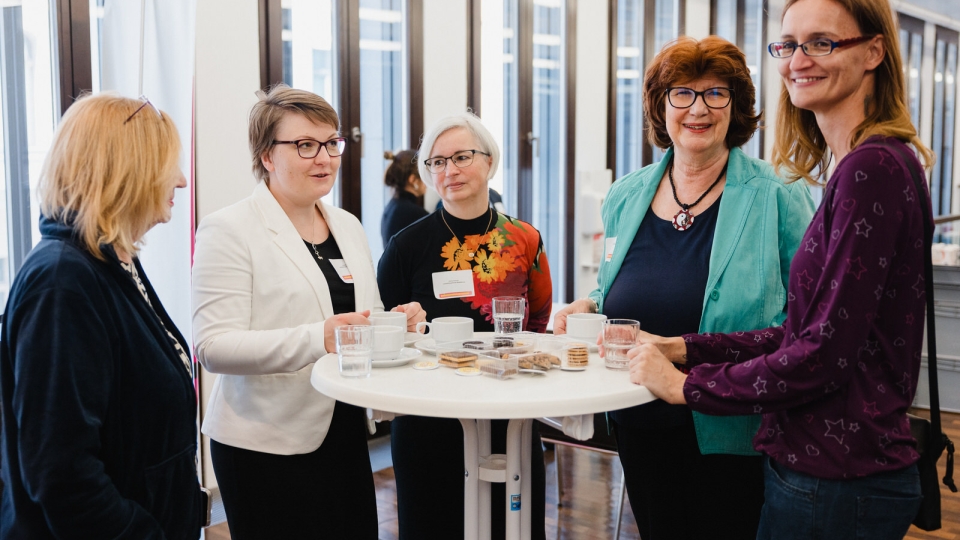 5 Frauen um einen Stehtisch