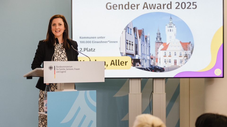 dunkelhaarige Frau am Rednerpult