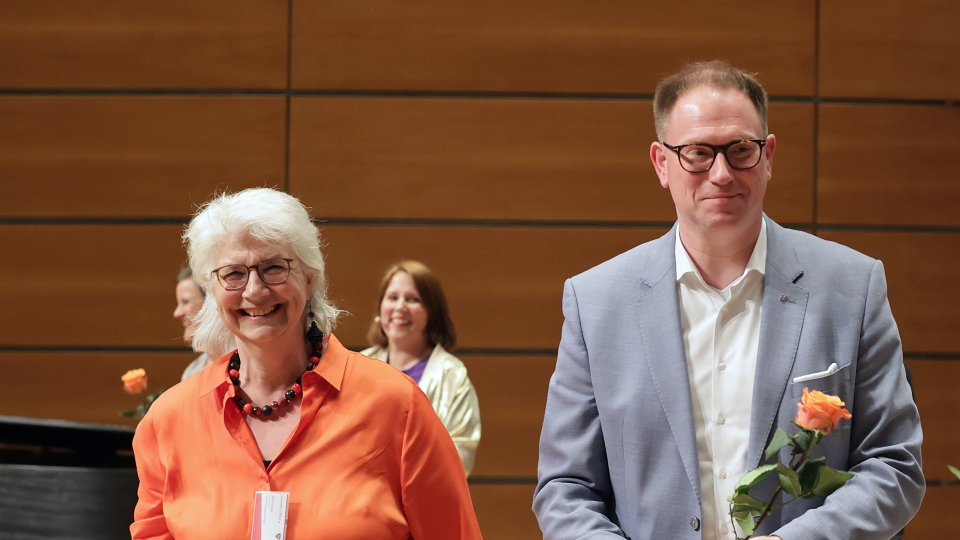 Gleichstellungsbeauftragte Elke Sasse mit oranger Bluse und weißen Haaren