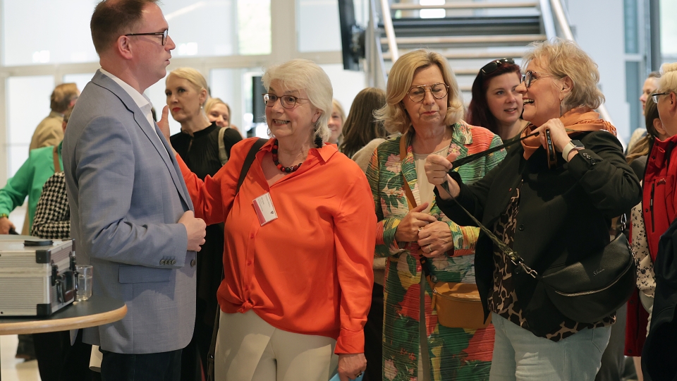 ein Mann mit blauem Anzeige und Frau mit orangener Bluse