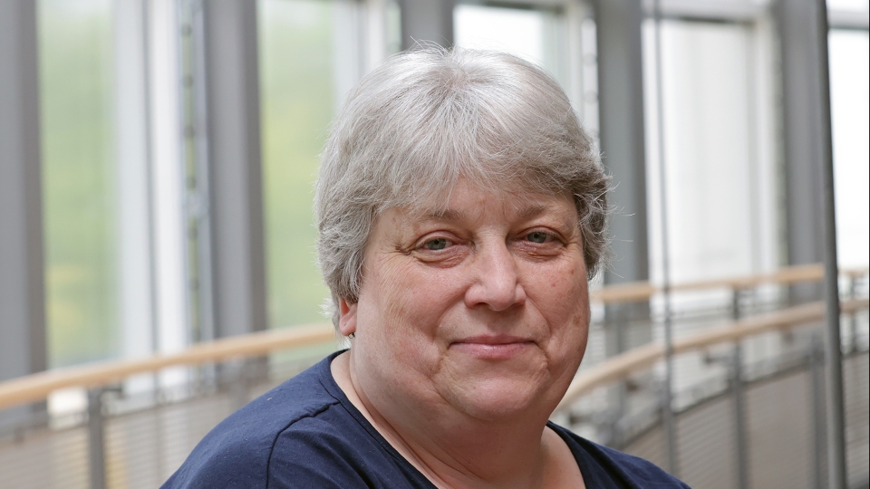 Frau mit kurzen Haaren und blauem Shirt