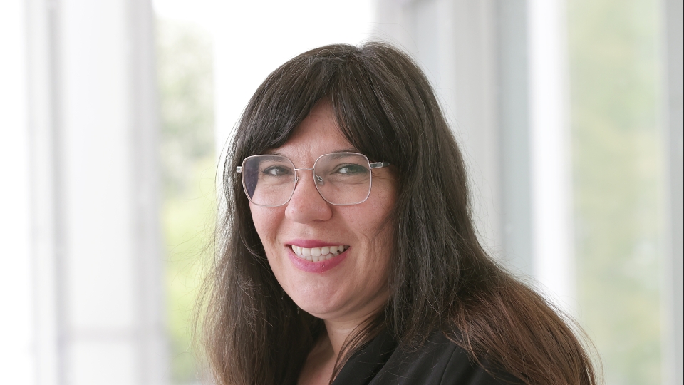 Frau mit langen braunen Haaren und Brille