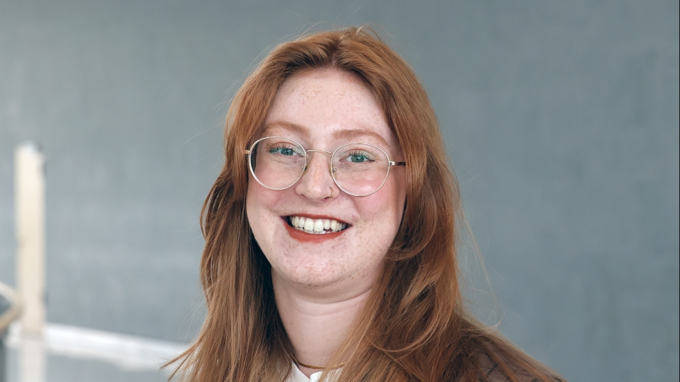 Frau mit langen roten Haaren und Brille