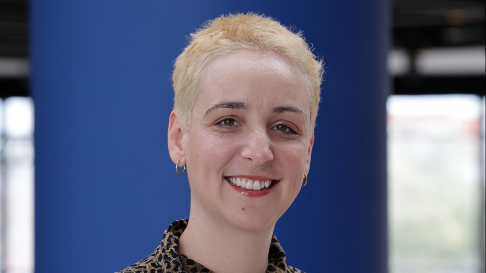 Person mit kurzen blonden Haaren und Bluse