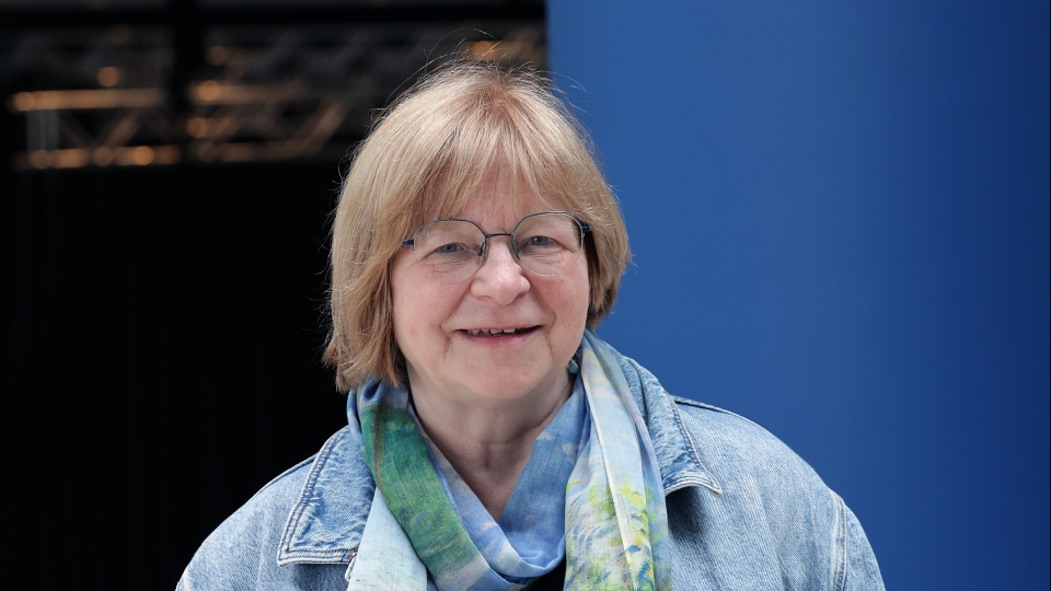 Frau mit kurzen Haaren, Brille und Jeansjacke