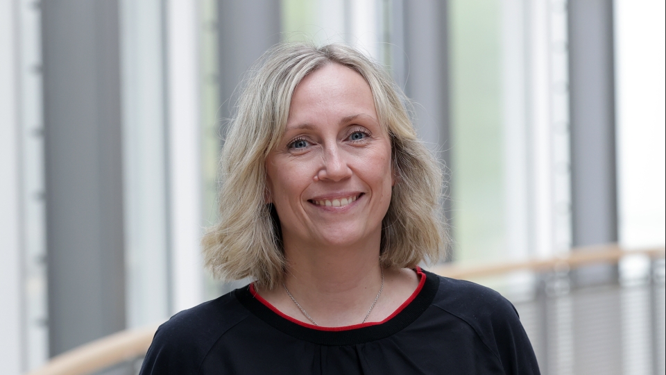 Frau mit schwarzem Oberteil und gewellten Haaren