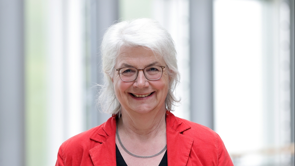 Frau mit rotem Sakko und Brille