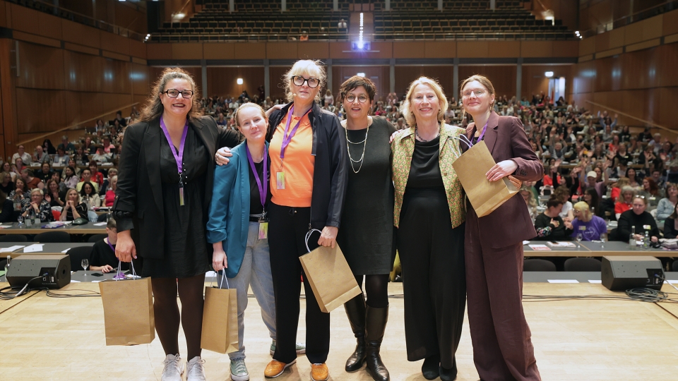sechs Frauen stehen in einer Reihe nebeneinander