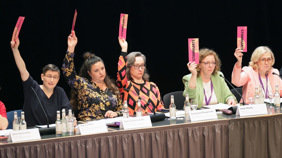 fünf Frauen halten Stimmzettel in die Luft