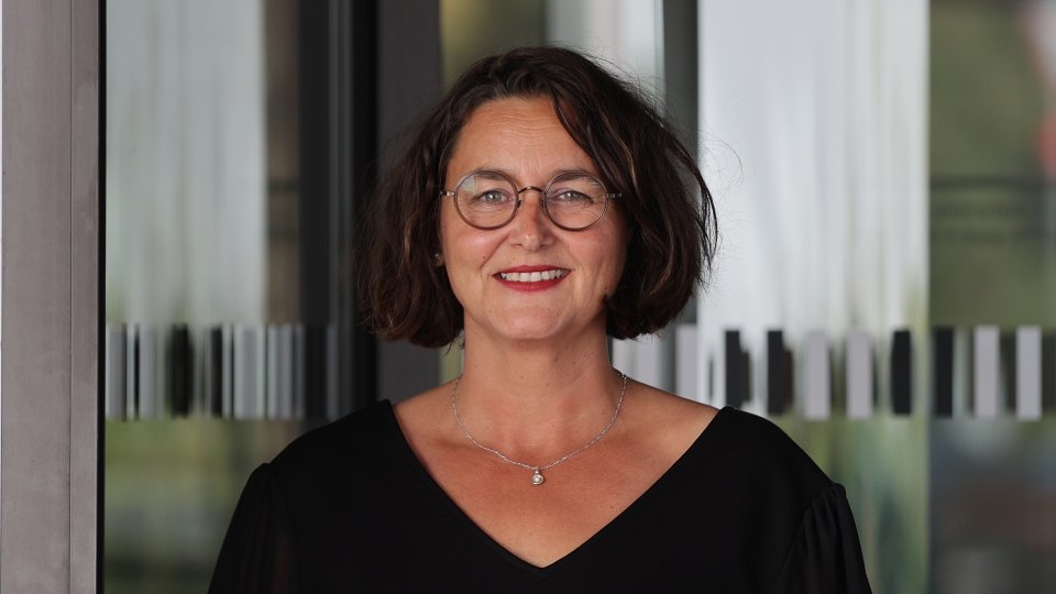 Frau mit schwarzen Haaren und Brille
