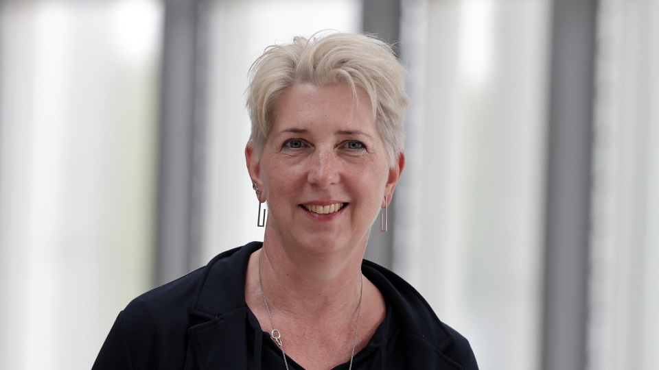 Frau mit kurzen Haaren und schwarzem Oberteil